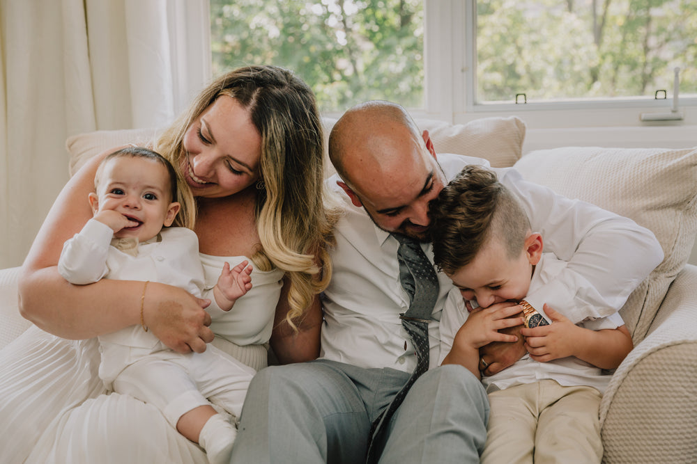a-young-family-sitting-together-on-a-beige-couch